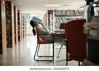 Asian student woman read books in library at university. Young girl stress tired have problem while study hard. Sadness concept - Powered by Shutterstock