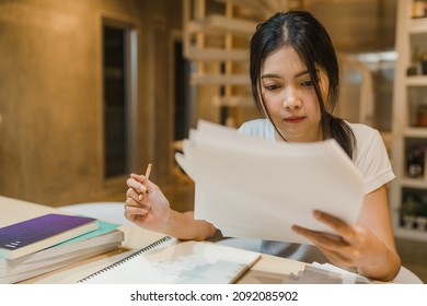 Asian Student Women Reading Books In Library At University. Young Undergraduate Girl Do Homework, Read Textbook, Study Hard For Knowledge On Lecture Desk At College Campus Overtime Night.