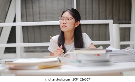 Asian Student Women Reading Books In Library At University. Young Undergraduate Girl Do Homework, Read Textbook, Study Hard For Knowledge And Education On Lecture Desk At College Campus.