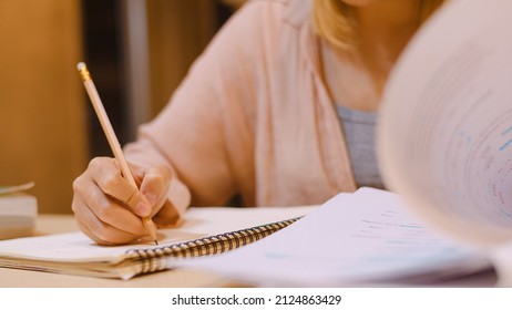 Asian Student Women Reading Books In Library At University. Young Undergraduate Girl Do Homework, Read Textbook, Study Hard For Knowledge On Lecture Desk At College Campus Overtime Night.