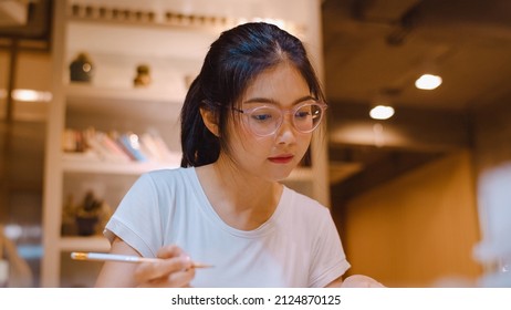 Asian Student Women Reading Books In Library At University. Young Undergraduate Girl Do Homework, Read Textbook, Study Hard For Knowledge On Lecture Desk At College Campus Overtime Night.