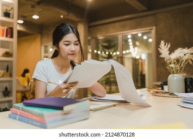 Asian Student Women Reading Books In Library At University. Young Undergraduate Girl Do Homework, Read Textbook, Study Hard For Knowledge On Lecture Desk At College Campus Overtime Night.