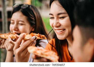 Asian Students Eating Eating The Pizza Together In Breaking Time Early Next Study Class Having Fun And Enjoy Party, Italian Food Slice With Cheese Delicious At University Outdoor.