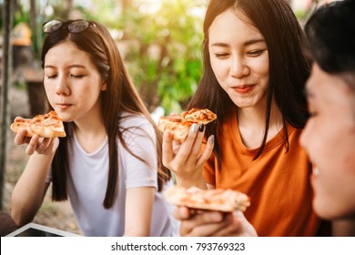 Asian Students Eating Eating The Pizza Together In Breaking Time Early Next Study Class Having Fun And Enjoy Party, Italian Food Slice With Cheese Delicious At University Outdoor.