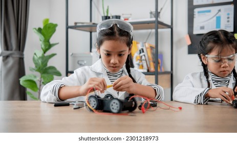 Asian students learn at home in coding robot cars and electronic board cables in STEM, STEAM, mathematics engineering science technology computer code in robotics for kids concept.