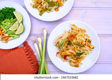 Asian Style Chicken Pad Thai Meal With Vegetables And Noodles, Isolated On A Wooden Lilac Background