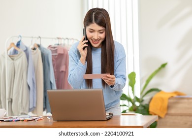 Asian Stylish And Designer Woman Working With Pantone Or Color Palettes For New Cloth Or Dressmaking Collection. Fashion Designer Tailor Looking In Color Sample To Selection In Her Workshop