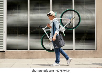 Asian Stylish Young Man Carrying Bicycle Outdoors