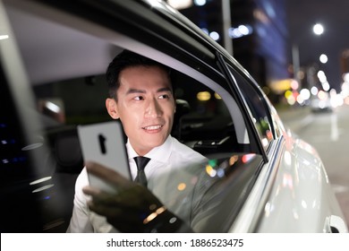 asian successful businessman use smart phone and look out of window in the car at night - Powered by Shutterstock