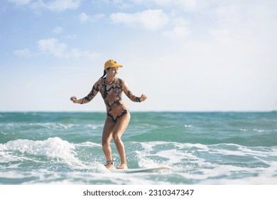 Asian surfing woman riding the waves on sunny day, outdoor activities, water sports activities concept - Powered by Shutterstock