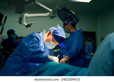 Asian surgeons work in a modern operating room - Powered by Shutterstock