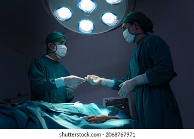 Asian Surgical Team Performing Surgery In The Hospital Operating Room