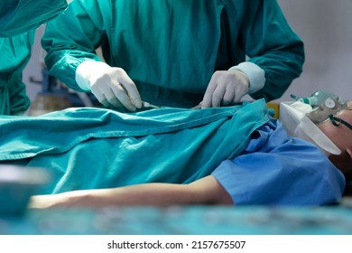 Asian Surgical Team Performing Surgery In The Hospital Operating Room