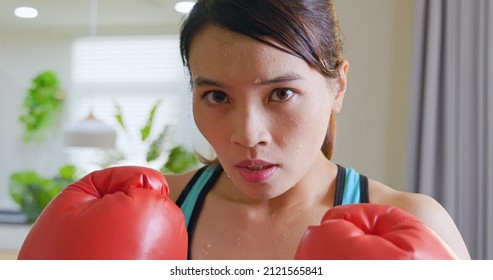 asian sweating sport woman doing boxing training at home