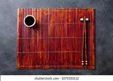 Asian table place setting with bamboo placemat, sauce bowl and chopsticks. Top view. Copy space. - Powered by Shutterstock