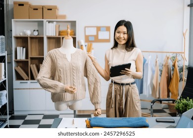 Asian tailor woman working on clothes in tailoring atelier. beautiful young female fashion designer smile and after success in studio

 - Powered by Shutterstock