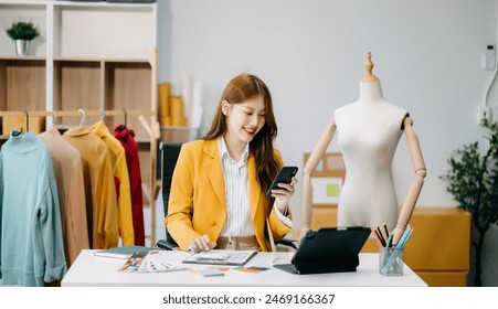 Asian tailor woman working on clothes in tailoring atelier. beautiful young female fashion designer smile and after success in studio
 - Powered by Shutterstock