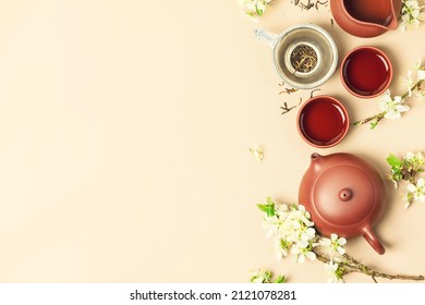 Asian Tea set on stone slate board, ceramic teapot, cups, dried tea and spring branches, tea ceremony, flat lay - Shutterstock ID 2121078281