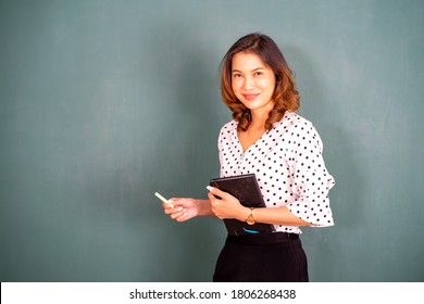 Asian Teacher At The Board With Books In Preschool For Disability Children.  Professional Woman Copy Space On Background Concept. 