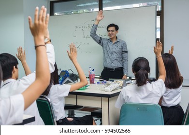 Asian teacher Giving Lesson to group of College Students which show hand for answer the question in the laboratory classroom, University education concept