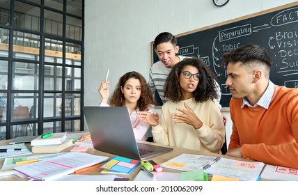 Asian teacher leader and multiethnic diverse young professional creative team students brainstorming discussing project at desk with in office classroom using laptop computer. Diversity. - Powered by Shutterstock