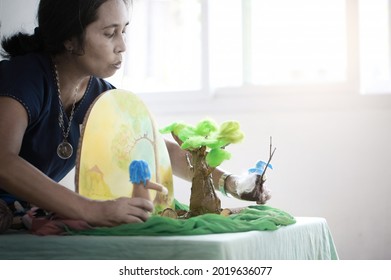 Asian  teacher telling story with hand made Waldorf dolls,home schooler and waldorf school concept background (soft focus and hi key photograph).