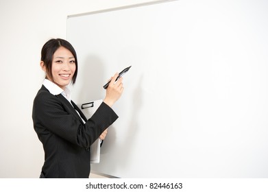 Asian Teacher Writing To Blank Whiteboard