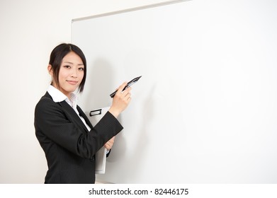 Asian Teacher Writing To Blank Whiteboard