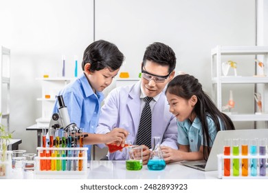 Asian teacher and young students engaged in chemistry experiments in school science lab - Powered by Shutterstock