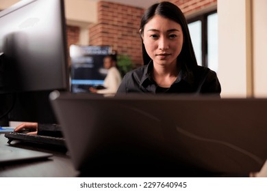 Asian tech enginner analyzing compiling html code on computer display, working on interface development. Software developer using terminal window with firewall server data in it big data agency