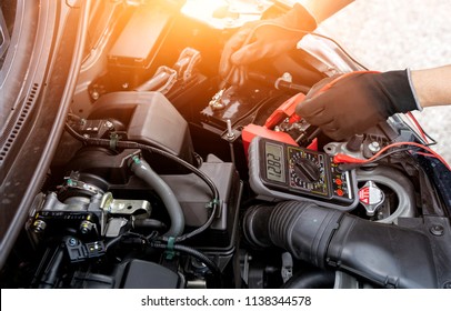 Asian Technician Measure Voltage Of Battery In The Car At Service Station, Maintenance And Repair