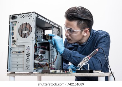 The Asian Technician Is Putting The CPU On The Socket Of The Computer Motherboard. The Concept Of Computer Hardware, Repairing, Upgrade And Technology.