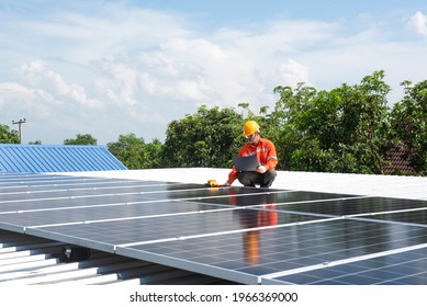 Asian technician Solar panels with a drill to install solar panels on the roof. - Shutterstock ID 1966369000