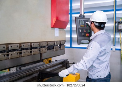 Asian Technician Worker Wearing A Safety Suit Setting Hydraulic Press Break Machine And Prepared Sheet Metal Shearing In Industrial Factory, Safety First Concept.
