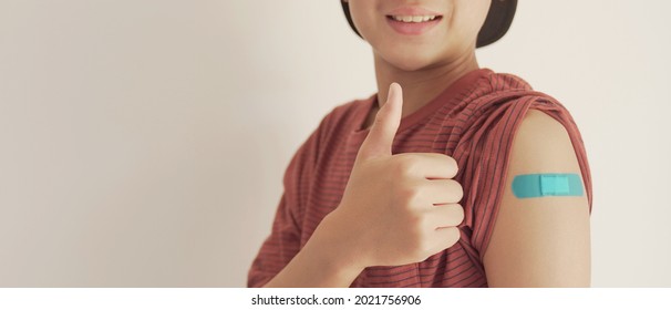 Asian Teen Boy Giving Thumb Up And Showing His Arm With Blue Bandage After Got Vaccinated Or  Inoculation, Child Immunization, Covid Delta Vaccine Concept