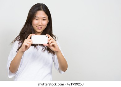 Asian teenage girl taking picture with mobile phone - Shutterstock ID 421939258