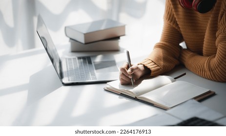 Asian teenage woman sitting in white office with laptop, she is a student studying online with laptop at home, university student studying online, online web education concept. - Shutterstock ID 2264176913