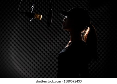 Asian Teenager Adult Woman Black Hair Cap Pony Tail Sing Song Loudly With Power Sound Over Hanging Microphone Condenser Filter In Black Shirt. Studio Back Low Lighting Sound Proof Absorbing Wall Room