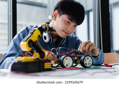 Asian Teenager Doing Robot Project In Science Classroom. Technology Of Robotics Programing And STEM Education Concept.