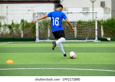 Asian Teenager Football Players In Blue Practicing Football At The Training Ground