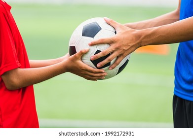 Asian teenager Football Players fair play handed a soccer ball to his brother - Powered by Shutterstock