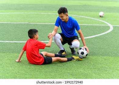 Asian teenager Football Players pulls the hand of a fallen player. - Powered by Shutterstock