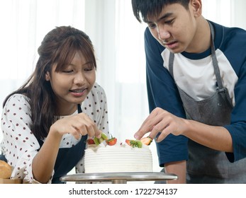 Asian Teenager Girl And Boy Learning How To Decorating Cake At Home, Lifestyle Concept.