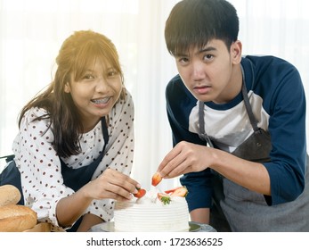 Asian Teenager Girl And Boy Learning How To Decorating Cake At Home, Lifestyle Concept.