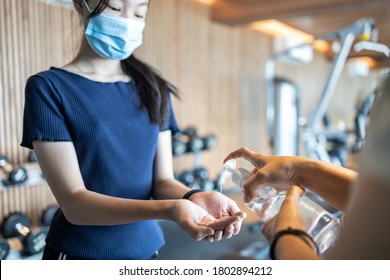 Asian Teenager Girl Is Cleaning Her Hands With A Disinfectant Alcohol Gel Before Touching Equipment In The Gym,people Wearing Protective Mask Before Entering The Fitness,new Normal Under The COVID-19 