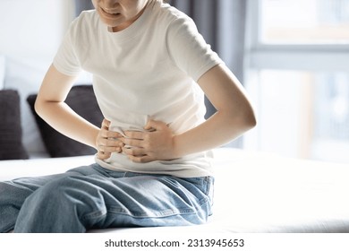 Asian teenager girl suffering from abdominal pain,gastritis,peptic ulcer disease,young woman with stomach ache,symptom of gastrointestinal disorders,stomach ulcer,gastric problem,health care,medical - Powered by Shutterstock