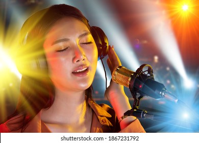 Asian Teenager Woman Black Hair Headphone Sing A Song Loudly Power Sound Over Microphone Condenser On Stage Ramp Lighting Beam As Concert, Copy Space