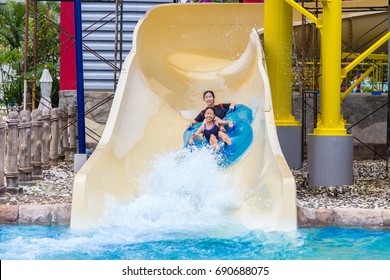 Asian Teenagers Enjoying Their Water Slider Ride At A Water Theme Park In Phuket, Thailand