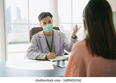 Asian thai doctor wearing mask talking to patient in diagnosis room. - Shutterstock ID 1689635356