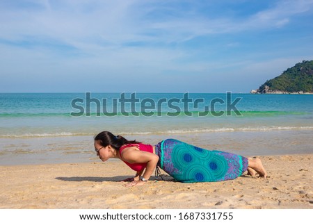Asian Thai woman practicing yoga in Ao Thong Nai Pan Noi beach, Koh Phangan island, thailand